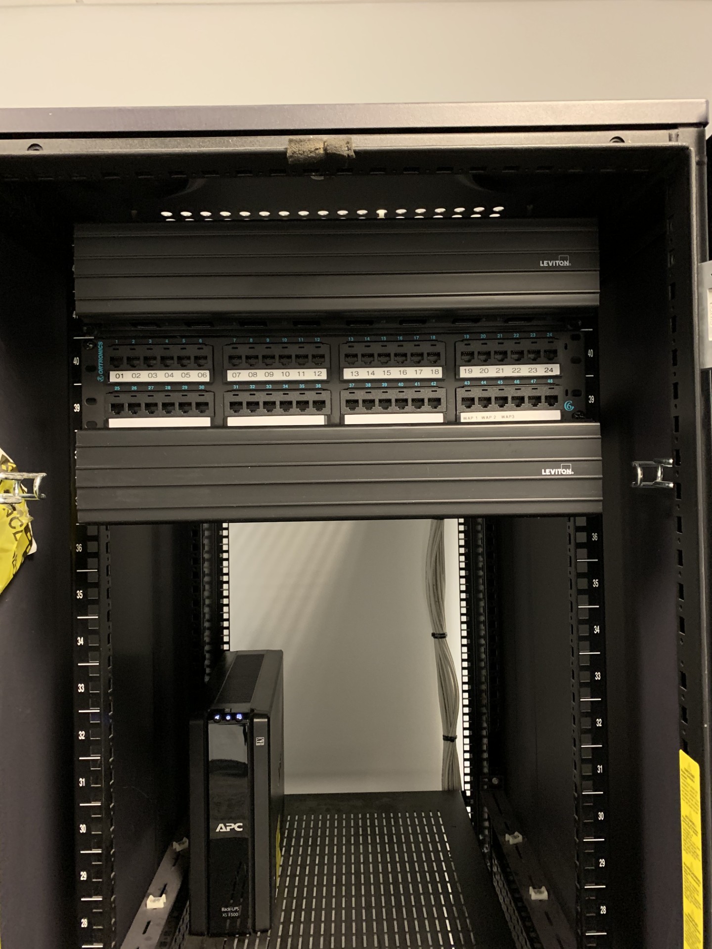 Structured cabling cabinet with labeled patch panels and power protection